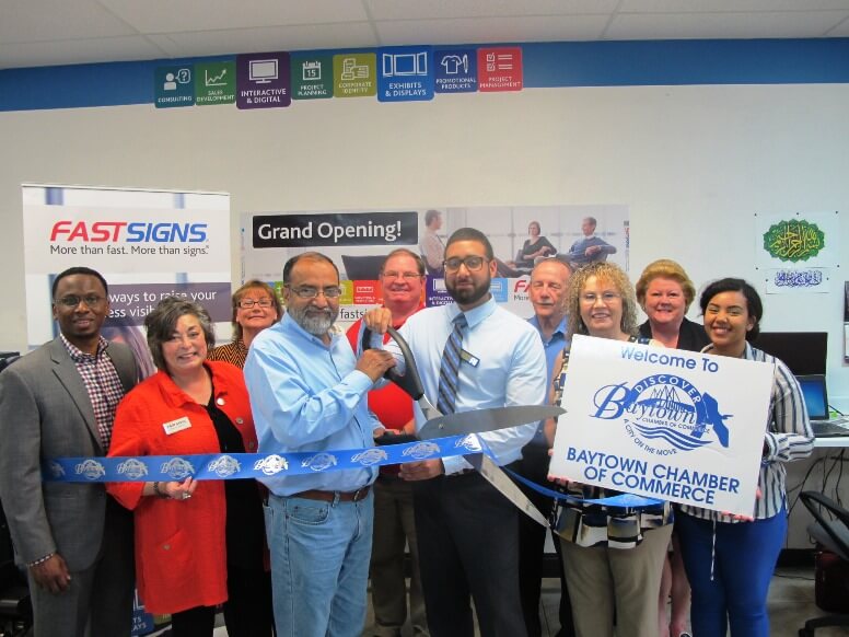 Group of people cutting the ribbon for a grand opening